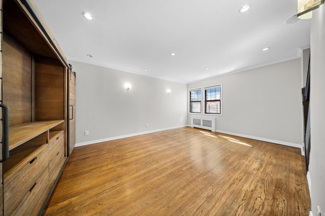 Spare room featuring ornamental molding, baseboards, wood finished floors, recessed lighting, and a barn door | Image 18