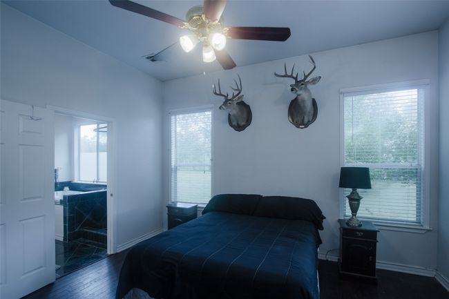 Bedroom featuring hardwood / wood-style flooring and ceiling fan | Image 21