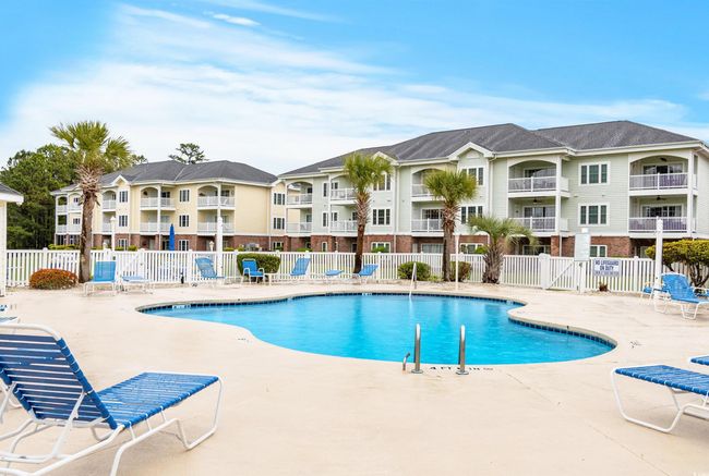 Community pool with fence and a patio area | Image 22