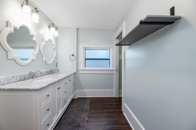 Bathroom featuring wood finished floors, double vanity, and baseboards | Image 22