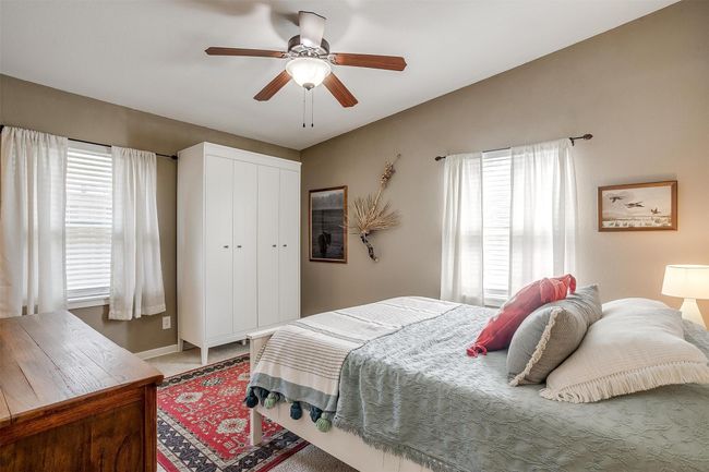 Carpeted bedroom with multiple windows, a closet, and ceiling fan | Image 14
