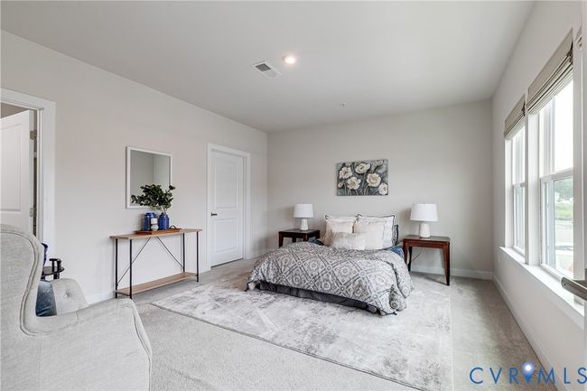 Spacious primary suite with plush carpet and soft natural light | Image 13