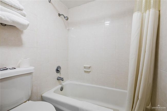 Bathroom featuring tile walls, toilet, and shower / tub combo | Image 15