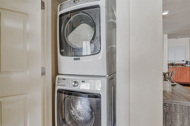 Laundry room featuring stacked washing machine and dryer | Image 12