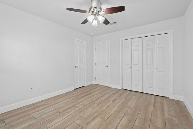 Unfurnished bedroom with light wood-type flooring, a closet, and ceiling fan | Image 30