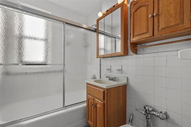 Full bathroom with vanity, enclosed tub / shower combo, and tile walls | Image 8