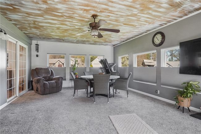 Sunroom with wood ceiling, carpet, outdoor dining area, and a ceiling fan | Image 21