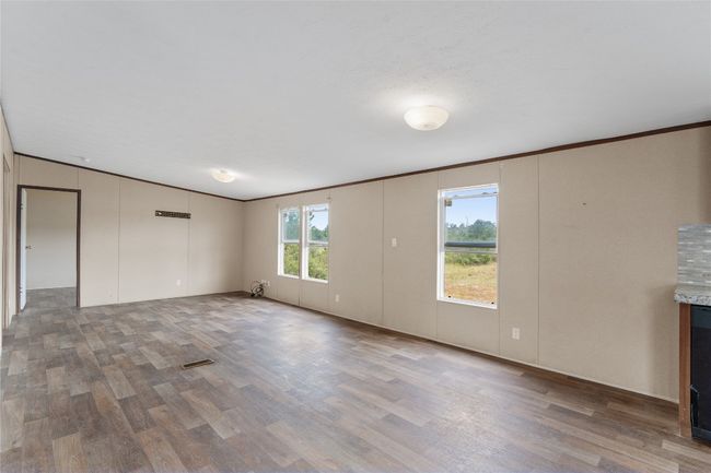 Unfurnished living room featuring vinyl finished floors and ornamental molding | Image 10
