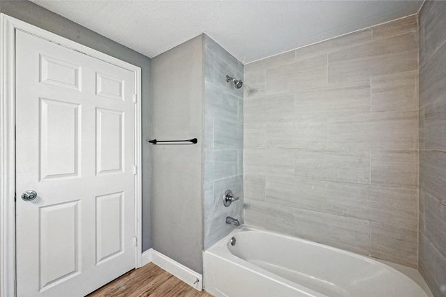 Bathroom featuring shower / bath combination and wood finished floors | Image 8