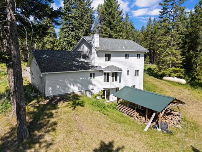 Rear view of house with a lawn, a chimney, and a shingled roof | Image 45