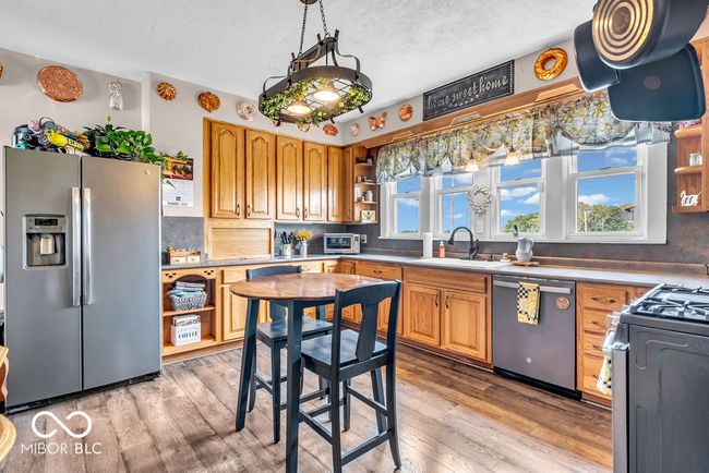 kitchen with stainless steel appliances, open shelves, decorative backsplash, and light wood-style floors | Image 24