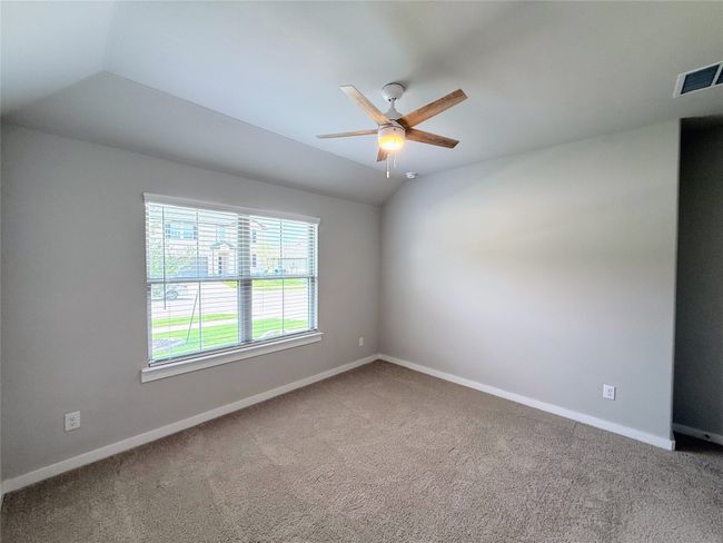 Empty room featuring ceiling fan, carpet, baseboards, and vaulted ceiling | Image 15