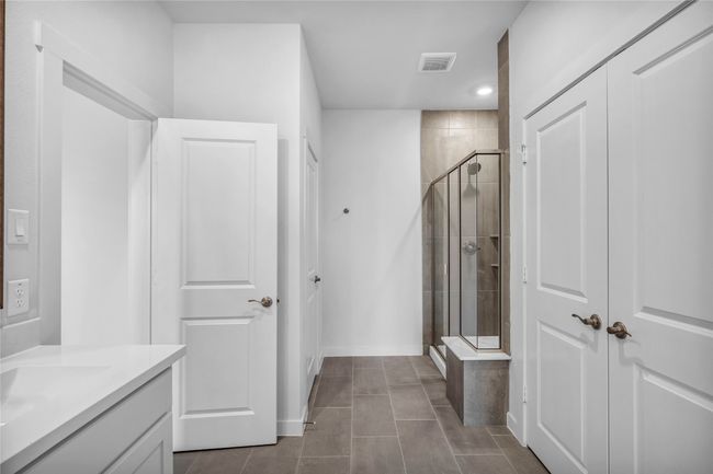Bright and spacious primary bath suite with dual sink vanity, shower, and private water closet. | Image 18