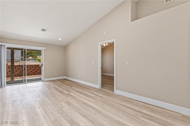 Empty room featuring light wood-style flooring, high vaulted ceiling, and recessed lighting | Image 20