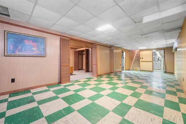 Finished basement with stairs, wood walls, a drop ceiling, and tile patterned floors | Image 29