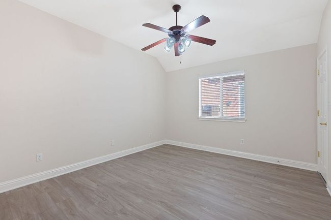 Empty room featuring baseboards, lofted ceiling, light wood-style floors, and a ceiling fan | Image 28