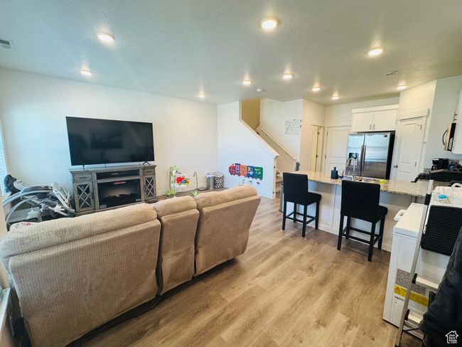 Living room featuring light wood-type flooring, recessed lighting, and stairway | Image 6