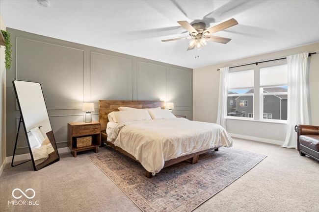 bedroom with light colored carpet, a decorative wall, and ceiling fan | Image 22