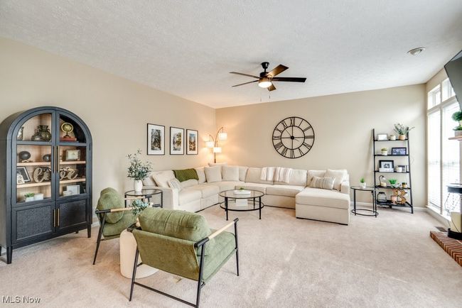 Living area featuring light colored carpet, ceiling fan, and a textured ceiling | Image 15