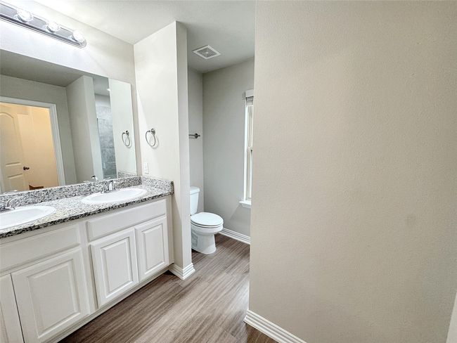 Full bath with wood finished floors and double vanity | Image 8