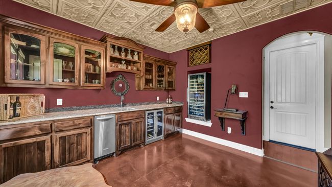 Indoor wet bar with wine cooler, a ceiling fan, finished concrete floors, and an ornate ceiling | Image 26