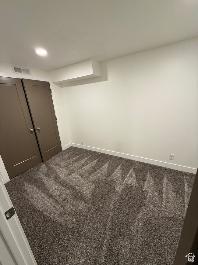 Interior space featuring visible vents, baseboards, and dark colored carpet | Image 15