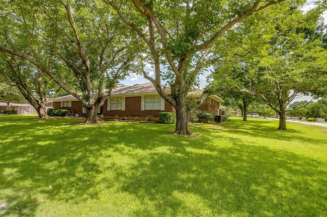 Ranch-style house with a front yard and brick siding | Image 6