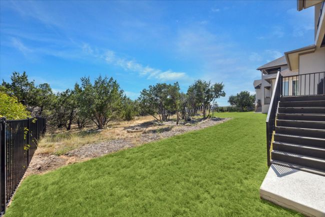 Stairs lead from the covered patio to the backyard, where a front and back automatic sprinkler system keeps the lawn lush and well-irrigated. Grass can added to cover the entire back yard if preferred. | Image 41