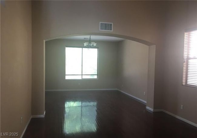 Unfurnished room featuring arched walkways, a chandelier, and dark wood finished floors | Image 10