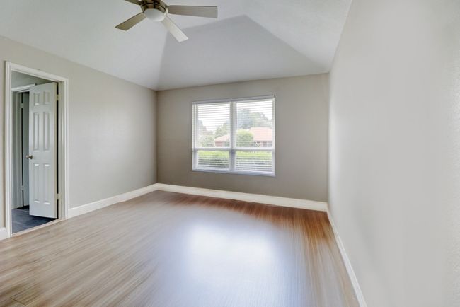 Unfurnished room featuring lofted ceiling, wood finished floors, and a ceiling fan | Image 14