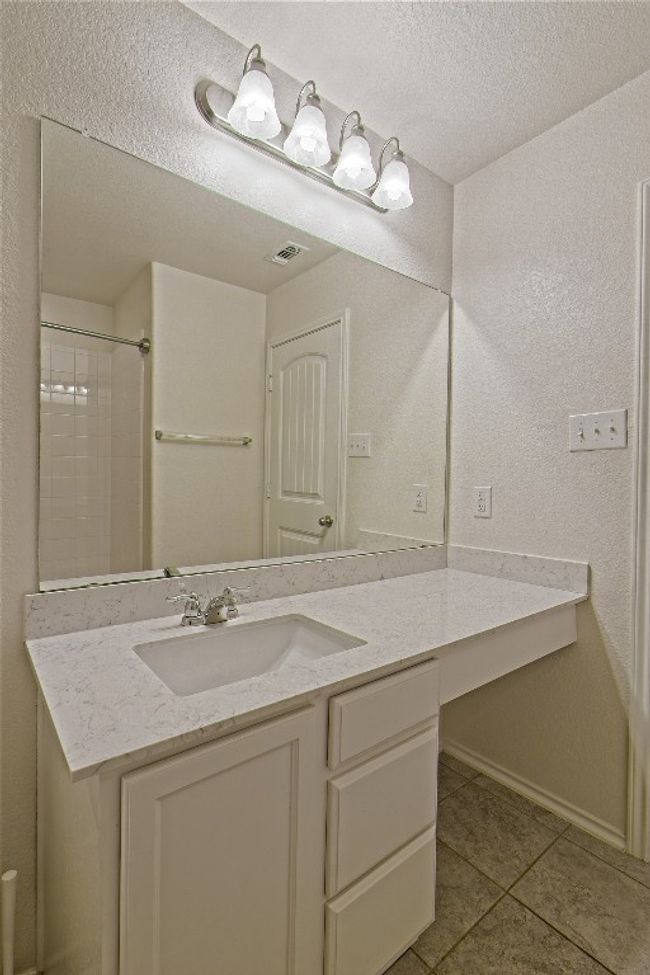 Bathroom with tile patterned floors, vanity, a textured ceiling, and a shower | Image 28
