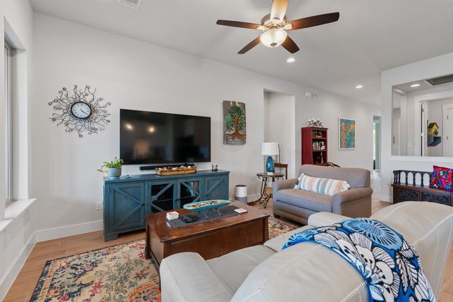Living area featuring light wood-type flooring, a ceiling fan, recessed lighting, and baseboards | Image 10