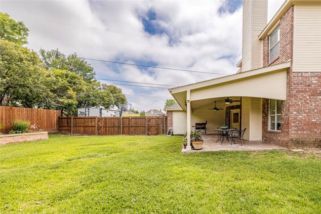 View of yard featuring a ceiling fan and a patio area | Image 38