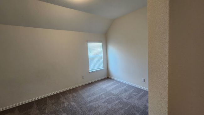 Empty room with dark colored carpet, lofted ceiling, and baseboards | Image 27