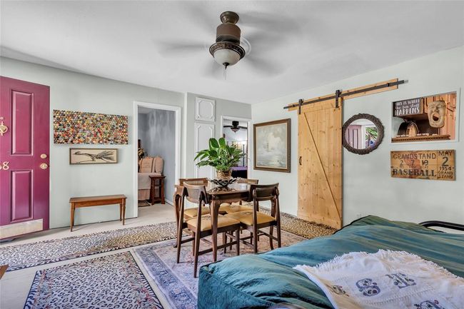 Dining room with ceiling fan and a barn door | Image 33