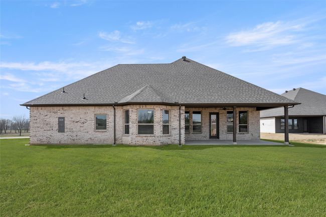 Back of house with a patio, a shingled roof, a lawn, and brick siding | Image 27