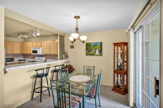 Dining area with an inviting chandelier and light colored carpet | Image 25
