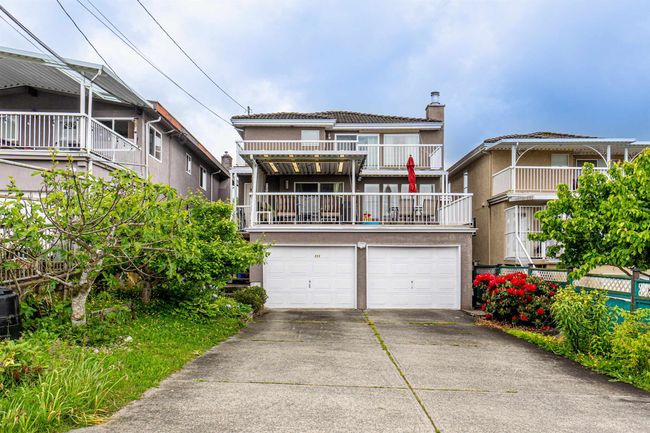 View of front of home featuring a chimney, concrete driveway, an attached garage, a balcony, and stucco siding | Image 31