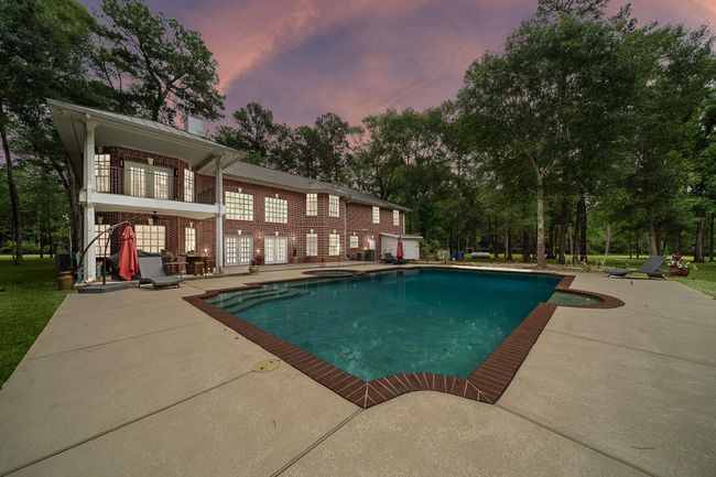 Backyard view of the home with a large pool and patio. | Image 45