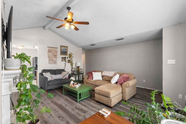 Living area with a ceiling fan, wood finished floors, and baseboards | Image 9