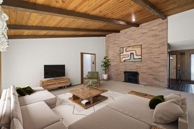 A brick wall with a built-in fireplace serves as the focal point of the room, adding warmth and a cozy ambiance to the space. Virtually Staged Photo. | Image 3