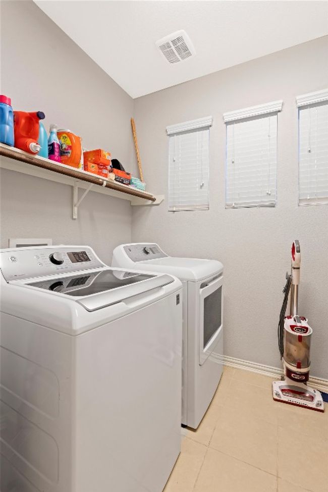 Laundry room with washer and clothes dryer and light tile patterned floors | Image 23