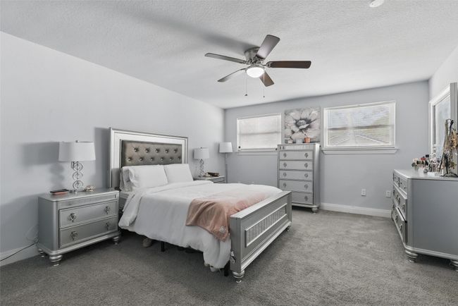 Carpeted bedroom with a textured ceiling, a ceiling fan, and baseboards | Image 25