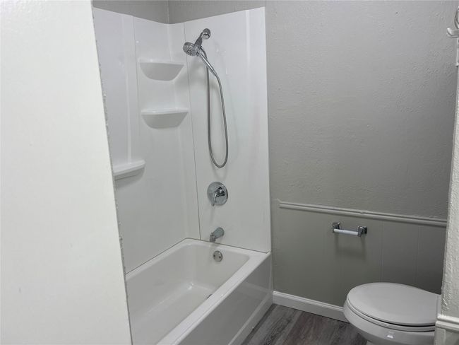 Bathroom with wood finished floors and shower / washtub combination | Image 17