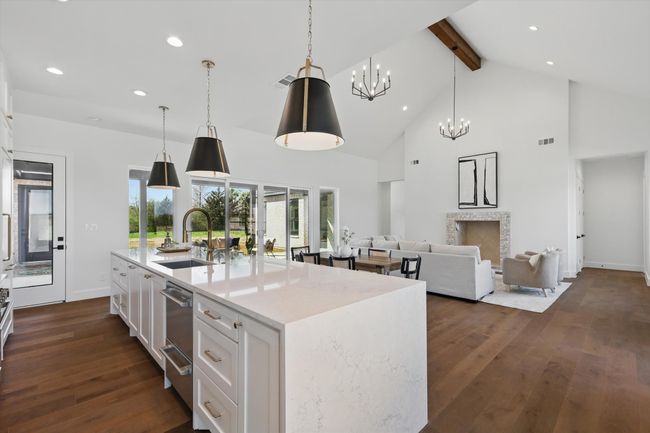 Kitchen featuring a sink, a chandelier, dark wood-style floors, beamed ceiling, and white cabinets | Image 8