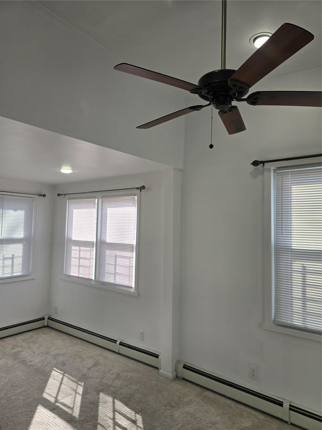 Unfurnished room with ceiling fan, baseboard heating, and light colored carpet | Image 20