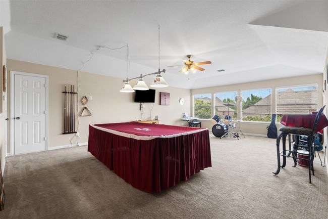 Game room featuring carpet, lofted ceiling, a ceiling fan, and baseboards | Image 36