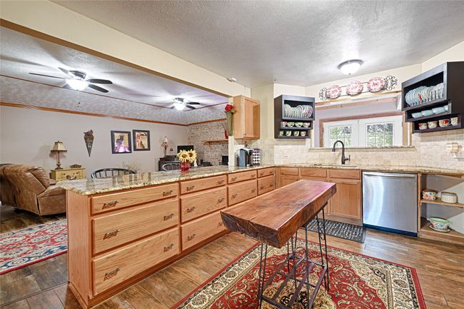 Kitchen with dark hardwood / wood-style floors, sink, stainless steel dishwasher, and a textured ceiling | Image 18