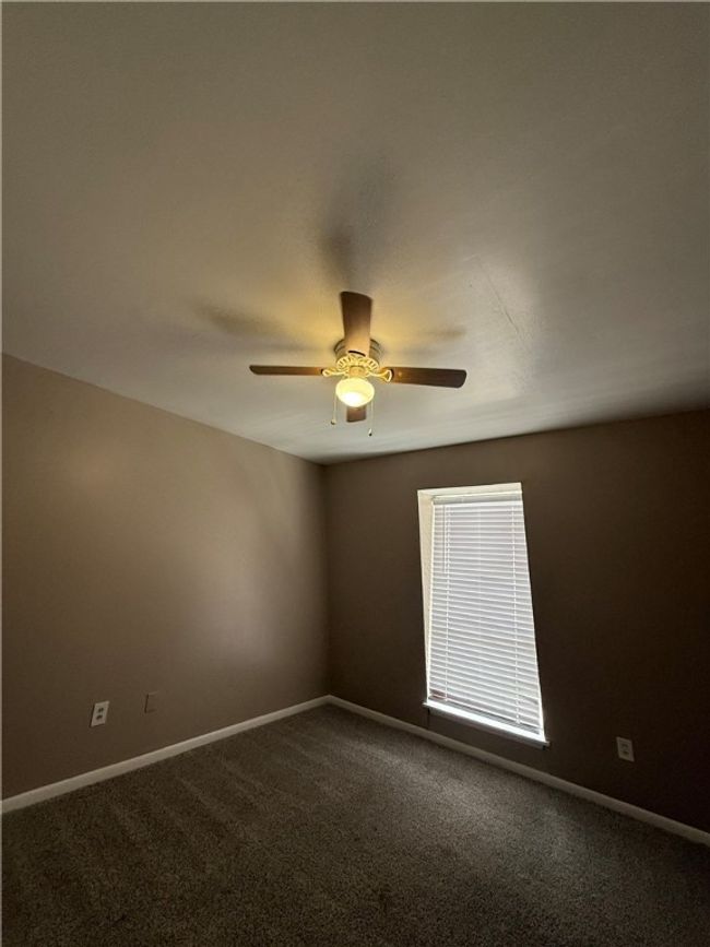 Unfurnished room featuring dark carpet and a ceiling fan | Image 9