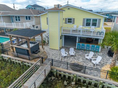 Rear view of property featuring a bar, an outdoor fire pit, a swimming pool side deck, and a patio | Image 3